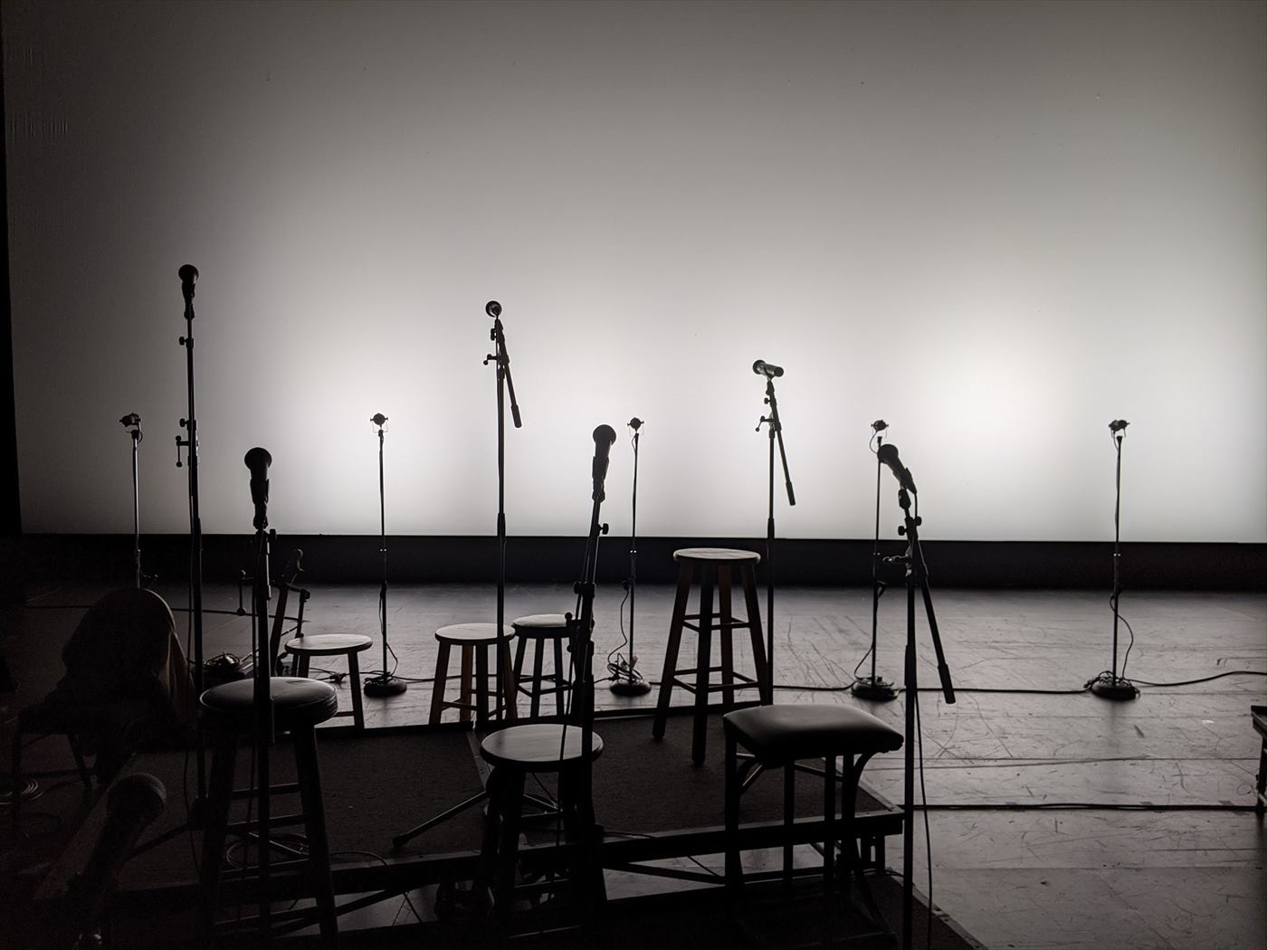 A row of microphones on an empty stage